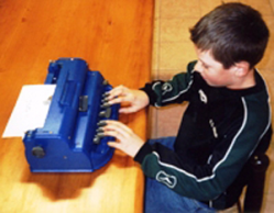Non-voyant apprenant à utiliser une machine pour écrire en braille
